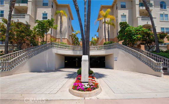 Entrance to an underground parking area of a building with floral landscaping and staircase access.
