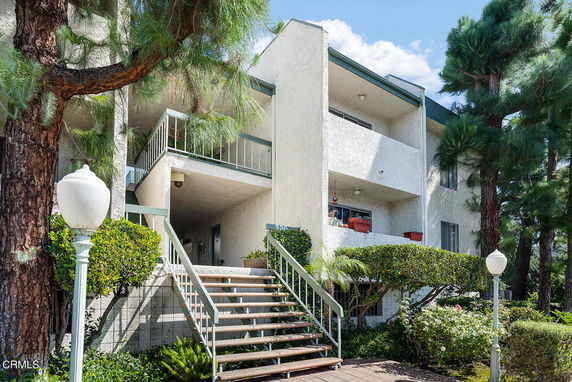 Front view of a multi-story building with exterior stairs and balconies.