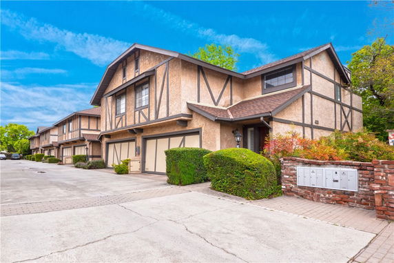Front view of townhouses with a double garage and Tudor-style design.