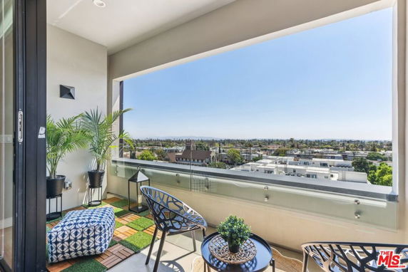 Balcony with chairs and plants overlooking cityscape