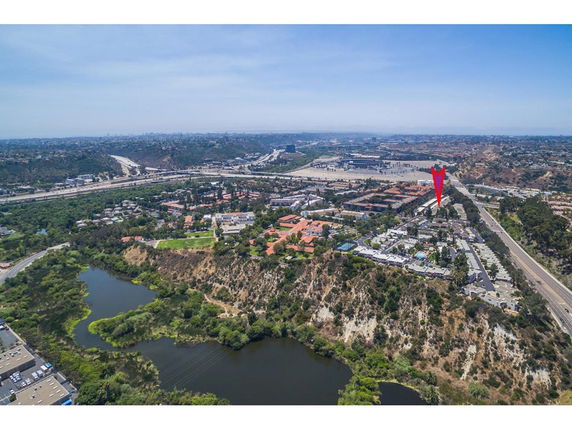 Panoramic view of a landscape with a road, buildings, and greenery.
