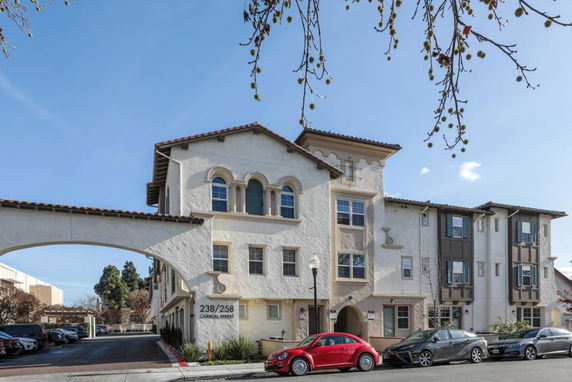 Front view of a multi-story building with an arched entrance.