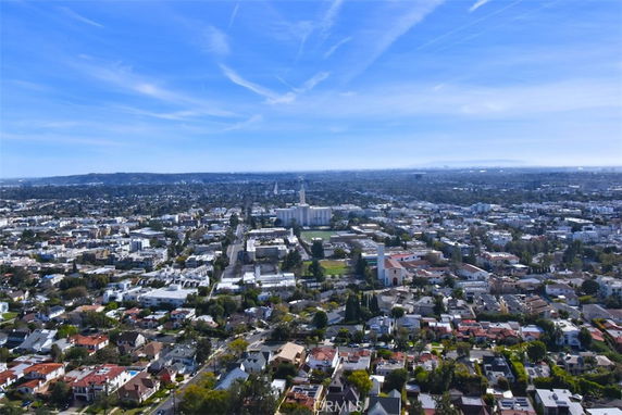 Wide-angle view of a cityscape with buildings and residential areas under a clear blue sky.
