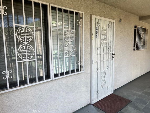 Front view of a house entrance with security bars on windows and door.