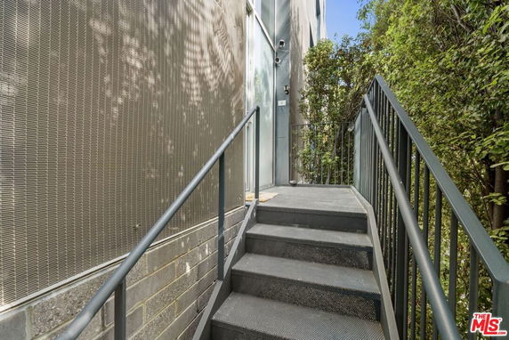 Exterior view of a metal staircase leading to a building entrance.
