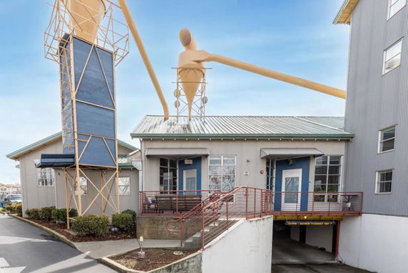 Front view of a building with a metal roof and unique architectural structures on the roof.