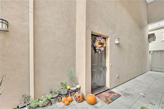 Entrance of a house with a decorated door and pumpkins.