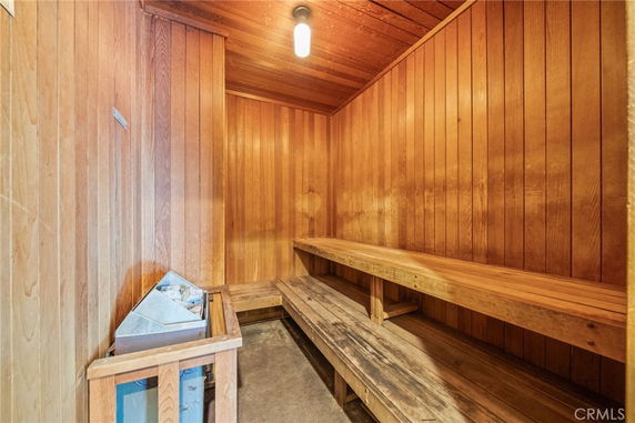 Interior view of a wooden sauna room with benches and a heater.