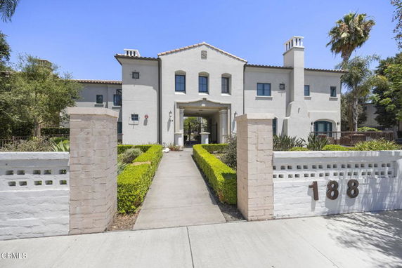 Front view of a two-story house with a central entrance and arch design.