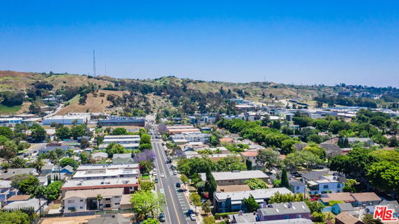 Wide angle panoramic view of a suburban area with houses, streets, and distant hills.