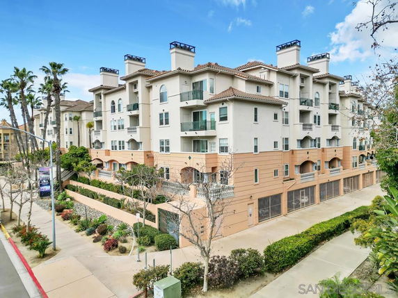 Front view of a multi-story residential building with balconies and a beige exterior.