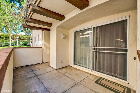 View from a patio area with sliding glass door and overhanging roof structure.