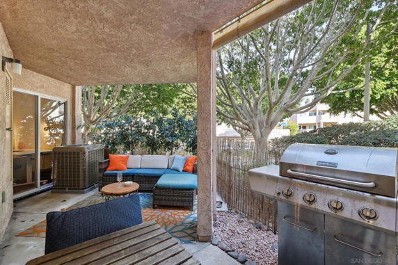 Outdoor patio area with seating and a barbecue grill.