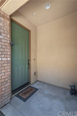 Exterior entrance with a green front door and welcome mat.