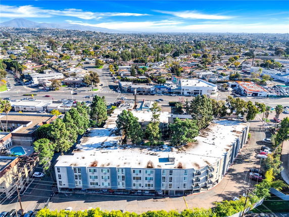 Aerial view of a multi-story residential building surrounded by urban landscape.