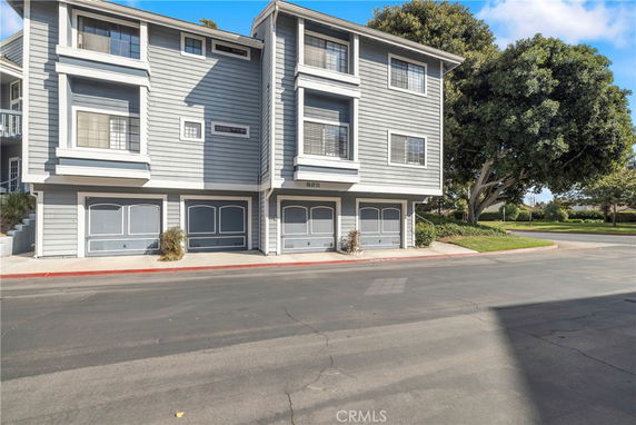 Front view of a multi-story building with garage entrances.