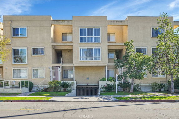 Front view of a multi-story apartment building with multiple windows.