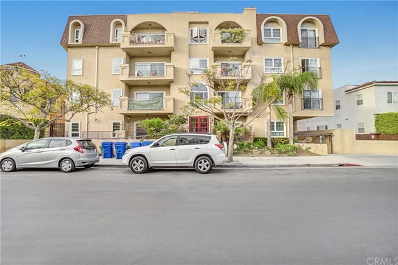 Front view of a multi-story apartment building with balconies.