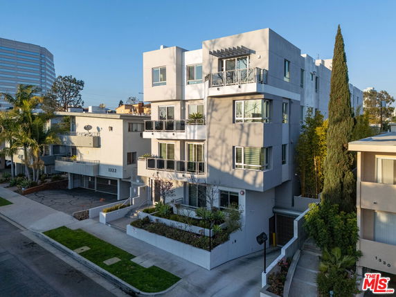 Front view of a modern multi-story apartment building with balconies.