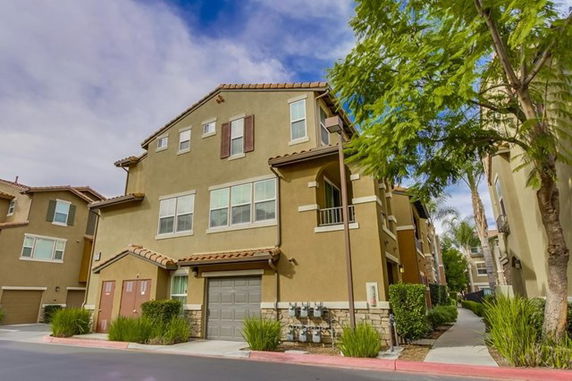 Front view of a multi-story residential building with a garage.