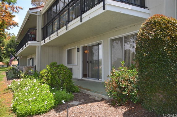 Front view of a two-story building with balconies and sliding doors.