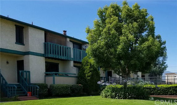 Front view of a two-story apartment building with green balconies.