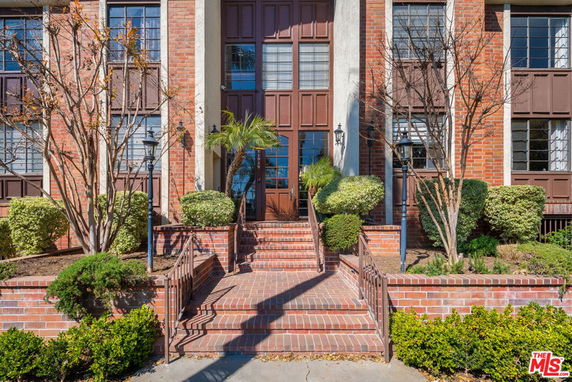 Front view of a brick building with steps leading to the entrance.