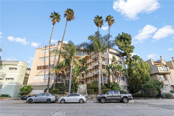 Front view of a multi-story apartment building with balconies.