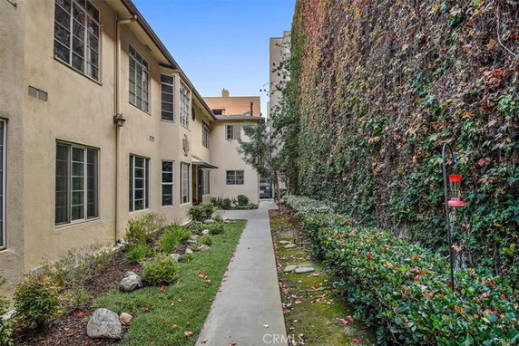 Exterior view of a multi-story building with a pathway and garden.