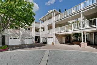Front view of a multi-story building with balconies and a garage.
