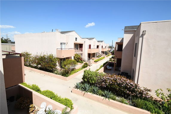 View of a residential complex with multiple two-story buildings and landscaped walkways.