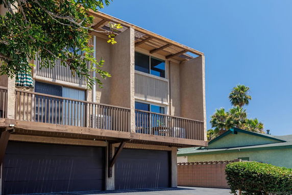 Front view of a multi-story building with balconies and a double garage.