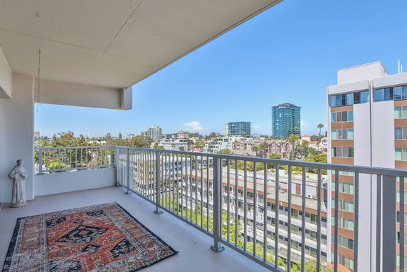 Panoramic view from a balcony showing surrounding buildings and skyline.