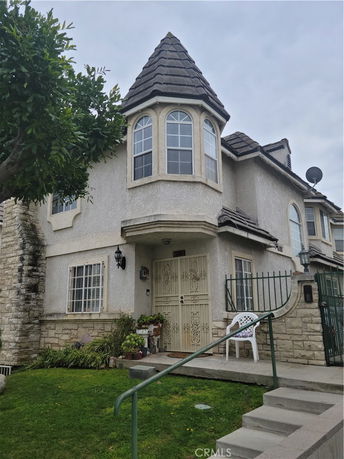 Front view of a house with a prominent turret and gated entrance.