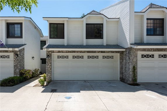 Front view of a two-story house with double garage and stone facade.