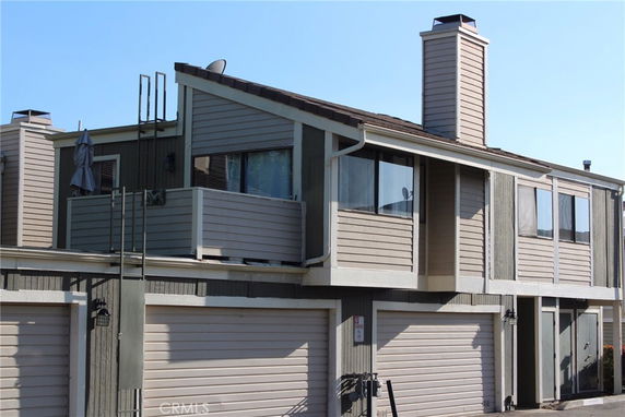 Front view of a two-story house with a double garage and multiple chimneys.