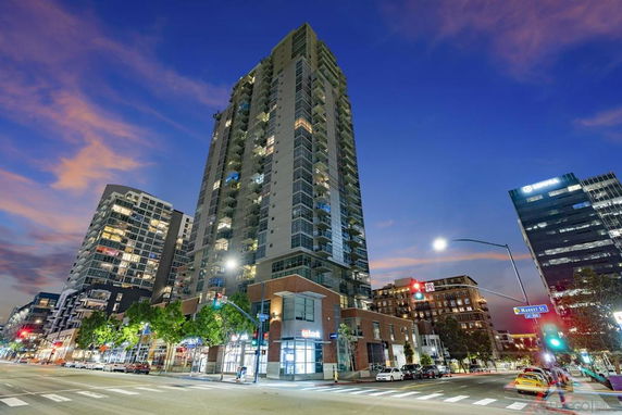 Front view of a high-rise building in an urban setting at dusk.