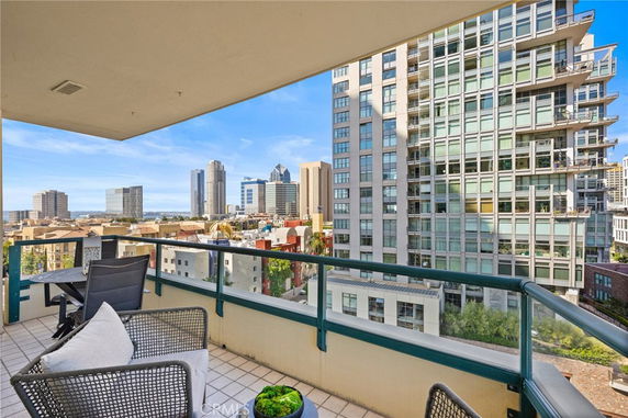 Panoramic view from a balcony overlooking a cityscape with tall buildings.