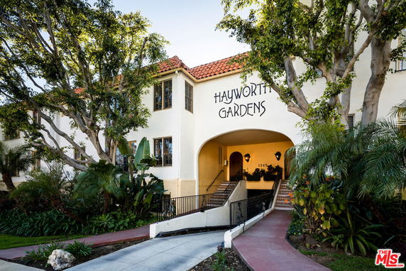 Front view of an apartment building named Hayworth Gardens with an arched entrance.