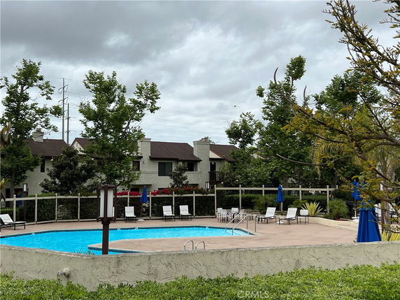 Outdoor swimming pool area with surrounding lounge chairs and umbrellas.