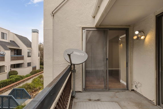 Balcony view showing neighboring buildings and a satellite dish.