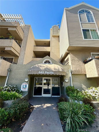 Front view of a multi-story building with balconies and large windows.