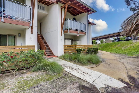 Front view of a two-story building with balconies and outdoor stairs.