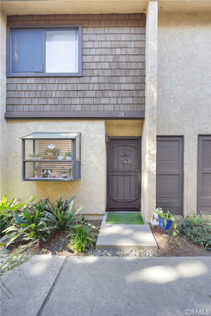 Front view of a two-story building with a single door entrance and a window box.