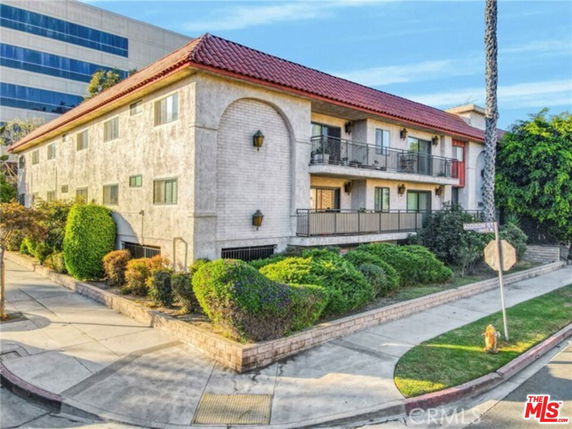 Front view of a two-story building with a red-tiled roof and balconies.