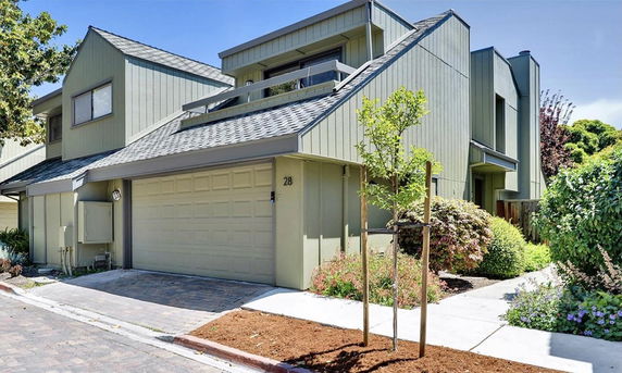 Front view of a modern multi-story house with a sloped roof and attached garage.