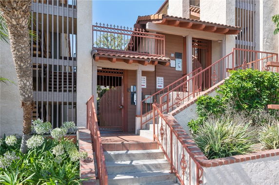 Front view of a building entrance with stairs and railing.