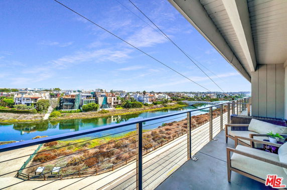 Wide angle view from a building showing a scenic river and houses on the opposite bank.