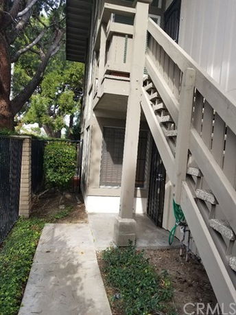 Side view of a two-story house with external stairs.