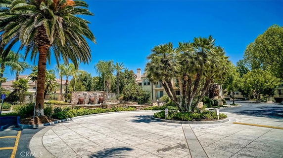 Circular driveway with surrounding palm trees and greenery.